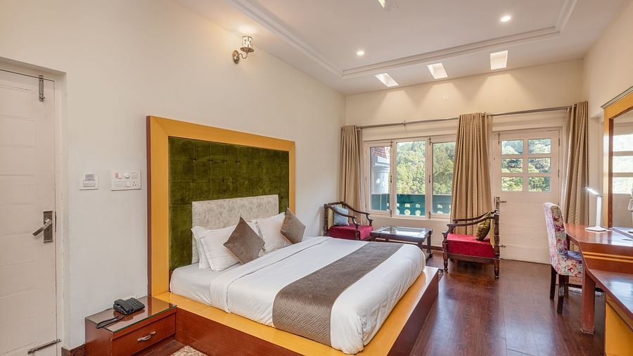 Comfortable and inviting room at DLS Tehri Club Resort with a warm colour scheme and hardwood floors.